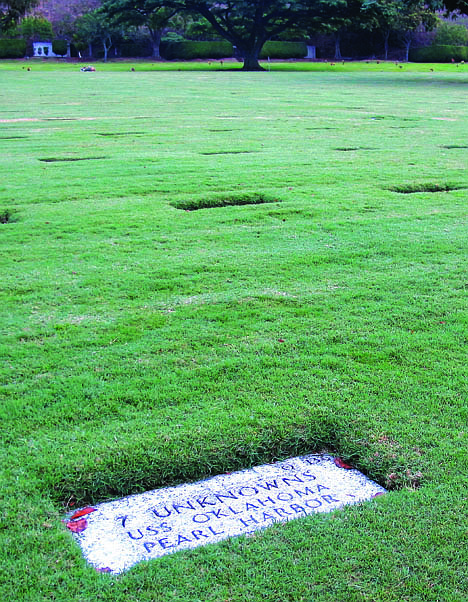 <p>A gravestone identifying it as the resting place of 7 unknowns from the USS Oklahoma who died in Japanese bombing of Pearl Harbor.</p>