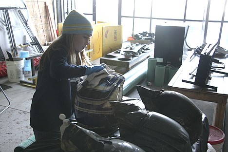 &lt;p&gt;Nine-year-old Celina McAlister scrubs a smoke-damaged motorcycle helmet on Saturday at the new Motion Sports building. The Coeur d'Alene motorcycle shop, formerly on Government Way, burned down Nov. 20 but has relovated to 174 E. Neider.&lt;/p&gt;