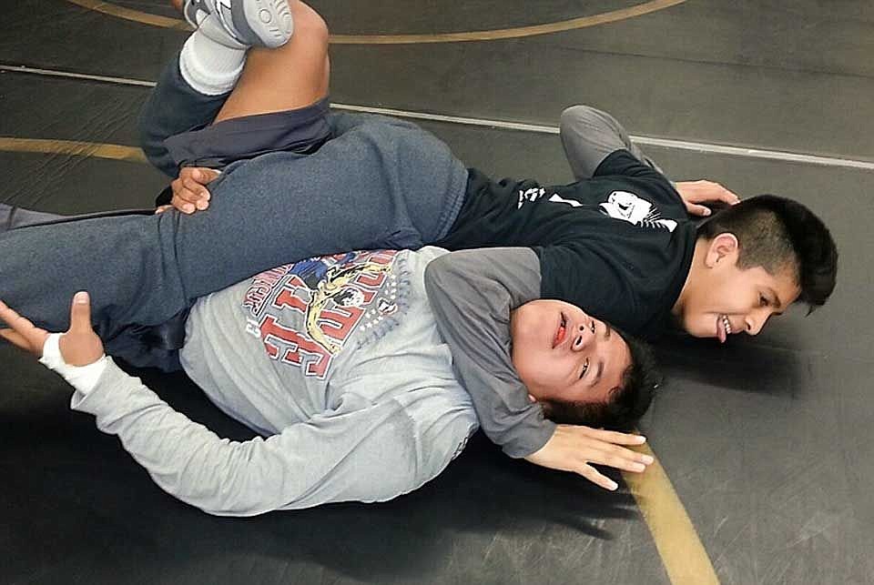 Sophomore Eduardo Rodriguez, third at state last season, top, practices moves and holds with senior second-place state winner Kiki Chabolla.