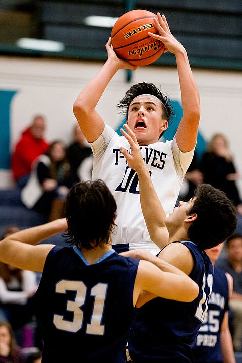 <p>Lake City's Kenneth Louie-McGee takes a shot over top of Bryan Cooper (31) and Sheadon Byrd of Gonzaga Prep on Tuesday at Lake City High School.</p>