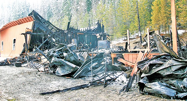The remains of what had been a two-story home at 412 Pioneer Road in Libby smolders on Friday.