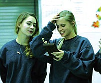 Juliana Spencer reads over her stats for the volleyball seasona as teammate Leandra Baldwin looks on. Each girl recieved a statuette with her statistics for the season on it.