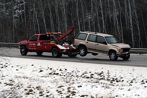 One of the vehicles involved in the crash, a Ford Explorer, is towed away from the scene of the accident.