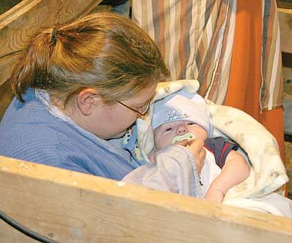Angela Magill (Mary) and her 10-week-old son Isaac (baby Jesus) take part in a live nativity scene during the Parade of Lights on Friday night in Libby. Following the parade, the crowd listened to middle-school principal Ron Goodman read &#147;A Christmas Story&#148; and enjoyed a few songs from the Libby&#146;s Children Select Choir. Javier Jimenz, 7, had the honor this year of switching on the lights to the community Christmas tree. More photos from the events will be published in the Dec. 24 edition of The Western News.