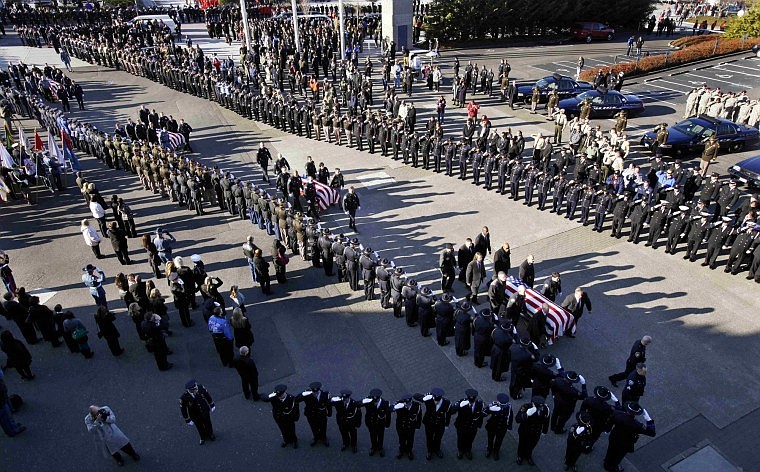 Four caskets arrive for a memorial service for four slain Lakewood police officers Tuesday, Dec. 8, 2009, at the Tacoma Dome in Tacoma, Wash. The memorial is being held a week after the officers were gunned down in a coffee shop before the start of their shift, Nov. 29. Killed were Sgt. Mark Renninger, 39, and officers Ronald Owens, 37, Tina Griswold, 40, and Greg Richards, 42.