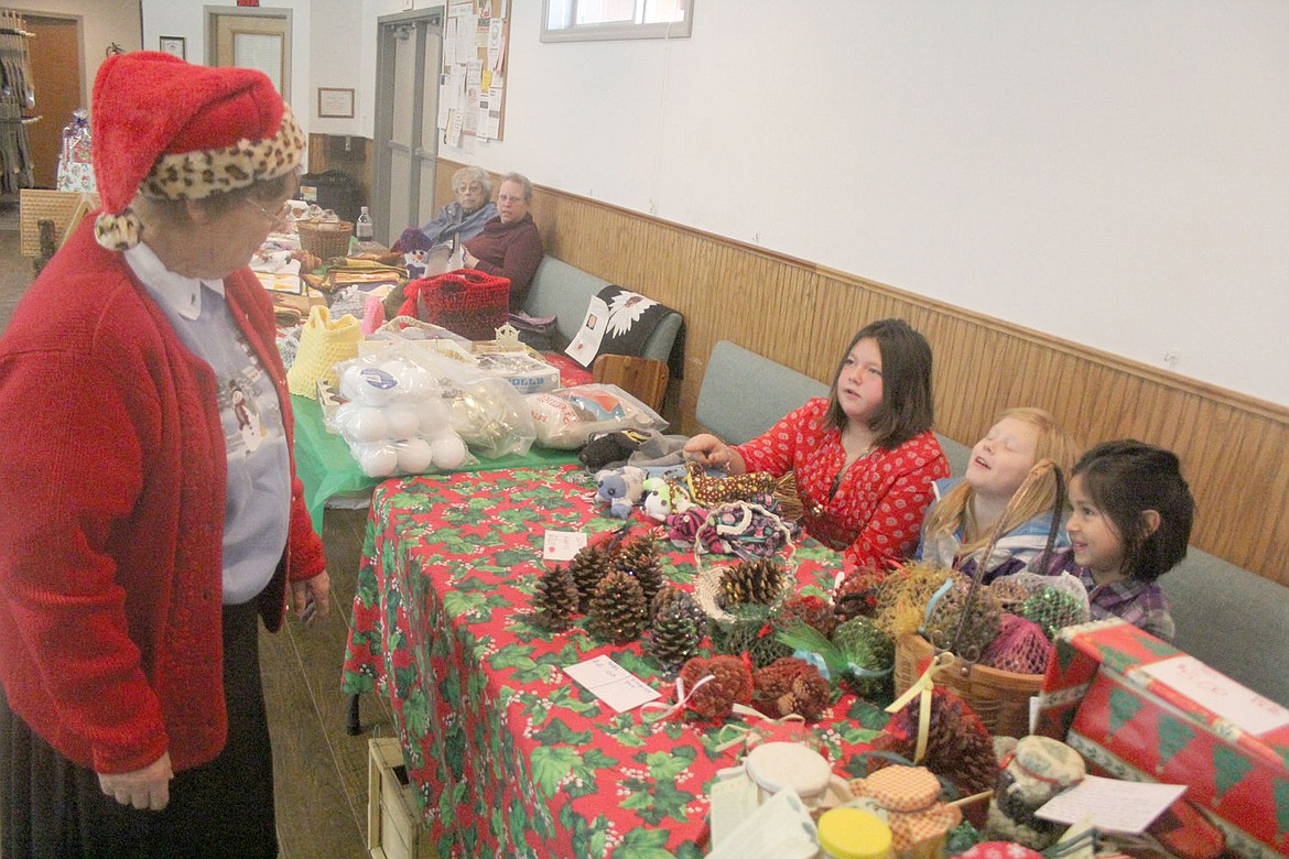 &lt;p&gt;Eileen Wolff examines the wares of three young vendors at the annual Christmas bazaar in St. Regis. The event raises money for a scholarship for a student that contributes community service.&lt;/p&gt;