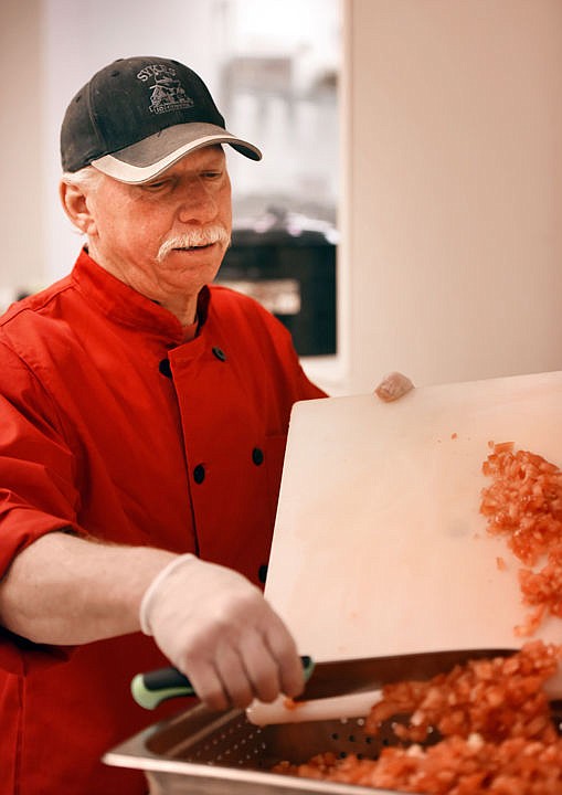 <p>Daniel Erickson, Dan the Salsa Man chops tomatoes as he does the prep work for a batch of his Blaine Mountain Salsa on Friday morning, December 9, in the commercial kitchen at Sykes in Kalispell. (Brenda Ahearn/Daily Inter Lake)</p>
