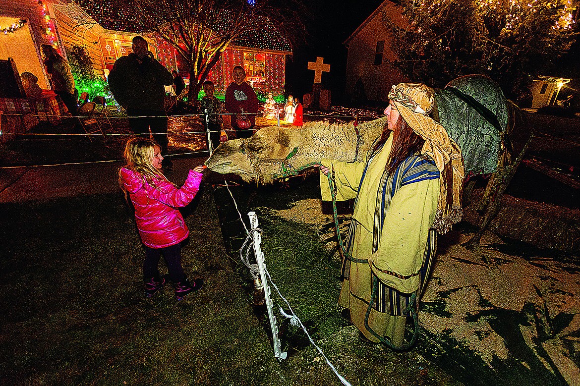 &lt;p&gt;SHAWN GUST/Press Brookelynn Jacobson, 8, feeds a carrot to to Dolly the camel as the animal&#146;s handler Jeannene Christ, of Cute as a Bug Mobile Petting Zoo and Camel Rides, holds the reigns Monday night at Jeremy Morris&#146; Hayden home. Morris is collecting donations from the public who attend the holiday festivities that includes a lighting display, free cocoa and treats and visits from Santa Claus. Funds raised through Monday, December 22 at 1473 W. Cardinal Avenue will benefit the Children&#146;s Village and the Emmett Paul Snyders Foundation.&lt;/p&gt;