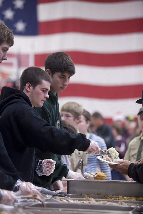 <p>Volunteer Tucker Spooner serves up a helping of mashed
potatoes.</p>