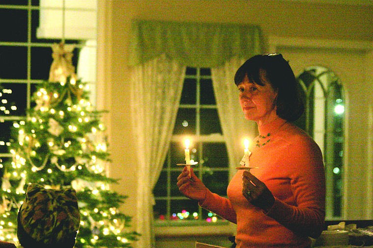 &lt;p&gt;Laura Lanfear holds up candles in remembrance of those who have passed while the reading of the names takes place.&lt;/p&gt;