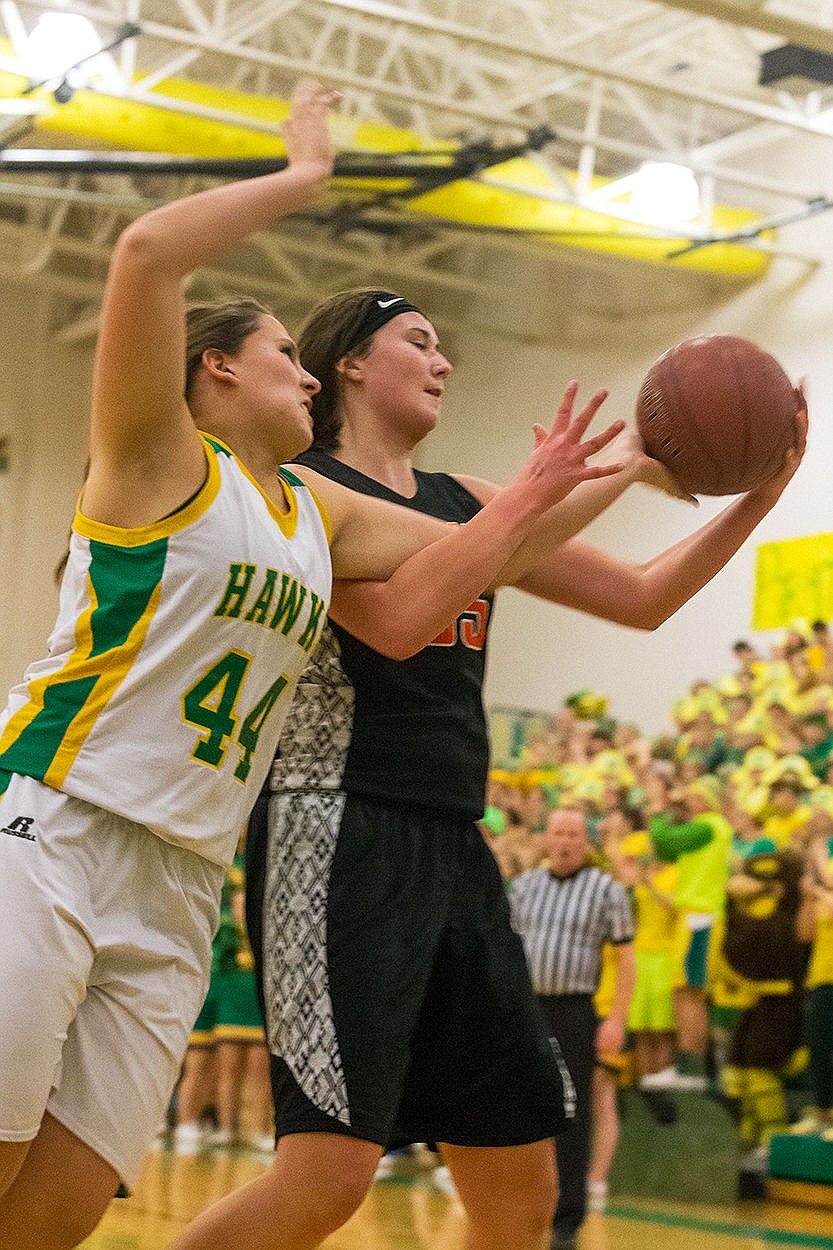<p>Lakelands Dani Dowd gets a hand on the ball as Post Falls Highs Sydney Parks goes up for a shot during the first quarter.</p>
