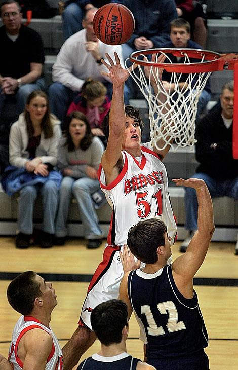 Flathead Braves' Brock Osweiler (51) shoots over Lake City's Brady Capaul (12) during first-half play Saturday at Flathead High School. Osweiler finished with a game-high 14 points as the Braves defeated the Timberwolves 57-46. Craig Moore/Daily Inter Lake