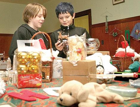 Photo by Aaric Bryan<br>Sam Wright and Marcus Simpson try to find a perfect gift for their parents at the Clark Fork Valley Women in Timber Parents' Gift Table at the Masonic Temple in Superior Saturday.