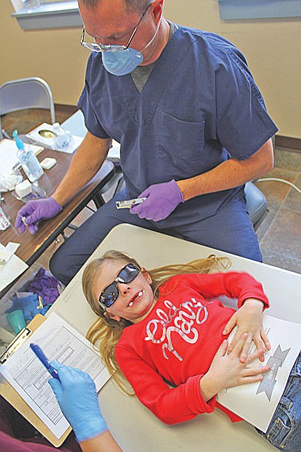 &lt;p&gt;Dental Hygenist Travis Fisher preps Lily Niblack for her treatment. To keep any potentially harmful things from getting in their eyes, the students all wore sunglasses.&lt;/p&gt;