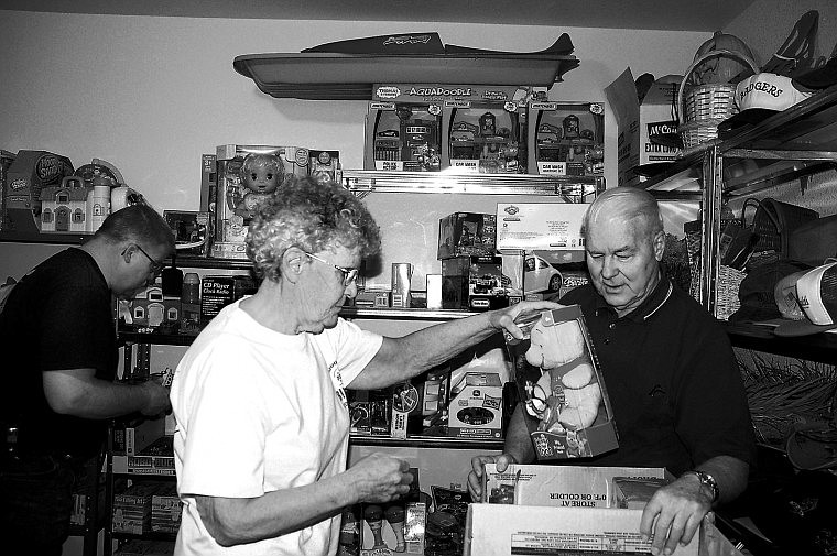 David Koon, left, looks through toys as his parents, Eldon and Annie Koon, plce toys in boxes for Toys for Tots.