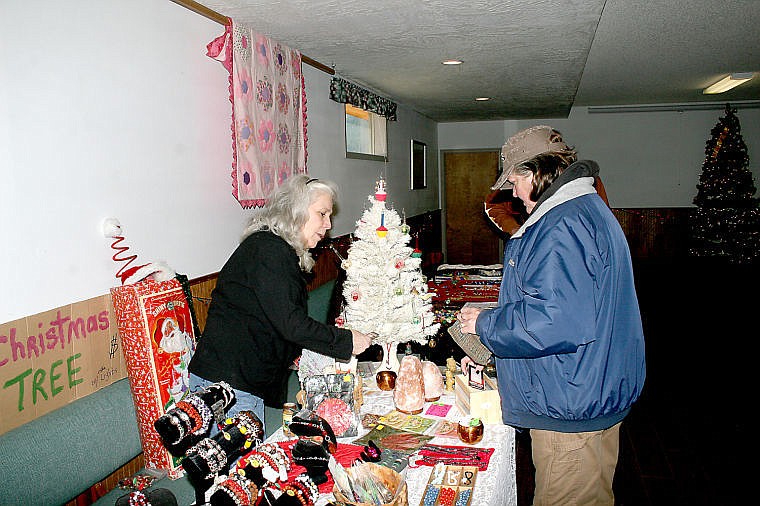 &lt;p&gt;Vicki Kraft works a transaction with Gayle Hendrick at the St. Regis Christmas Bazaar on Saturday.&lt;/p&gt;