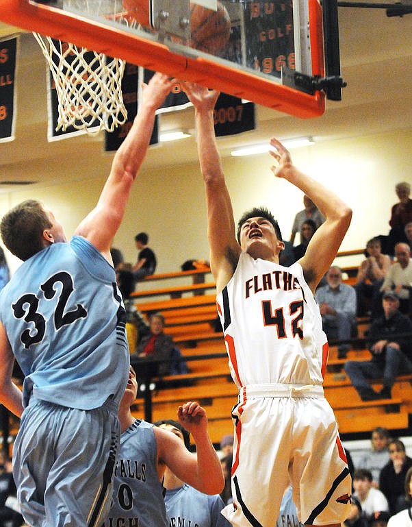 <p>Flathead's Micah Bucy puts up a shot over Great Falls' Brendan Howard during the third quarter on Saturday. (Aaric Bryan/Daily Inter Lake)</p>