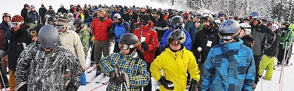 A large lineup of skiers and snowboarders wait for the chairlift at Chair One to open up at Big Mountain's opening day.