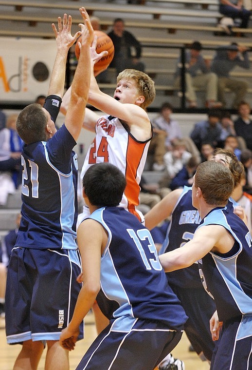 Flathead senior Karl Ingram (24) shoots while under pressure from Great Falls senior Schuyler Watt (21), junior Trey Skunkcap (13) during the second period of Saturday&#146;s nonconference game at Flathead. Great Falls High won 60-47.