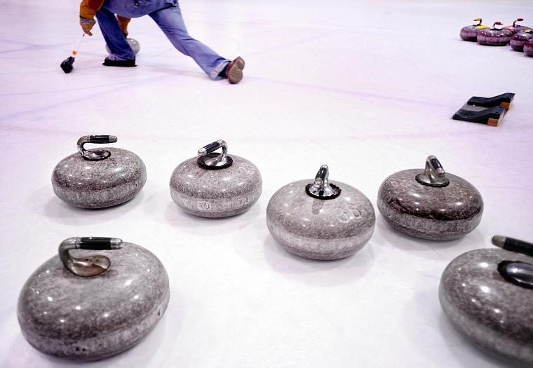 Before they acquired their own set of stones, members of the Whitefish Curling Club use these stones mined in Scotland in 1887, on loan from a Bismarck, N.D., club. In the background, Emily O’Neil of Columbia Falls works on her throwing.