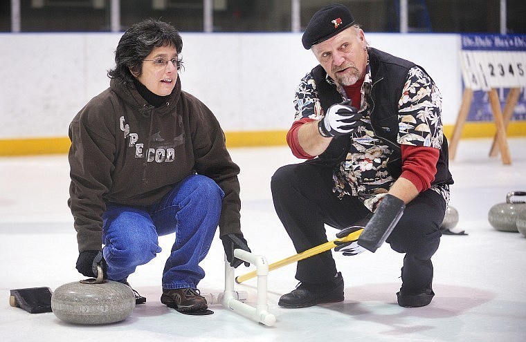 Gina Kiehn gets some basic instructions from John Hoepfer on her first night of curling.