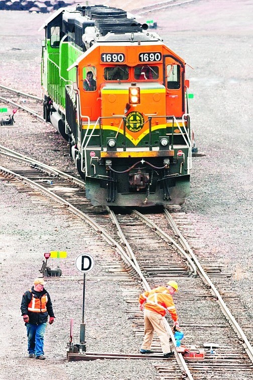 <p>Workers clear equipment from the tracks while moving a BNSF
train last week at the rail yard in Whitefish. BNSF Railway Co. has
hired 415 new workers this year.</p>