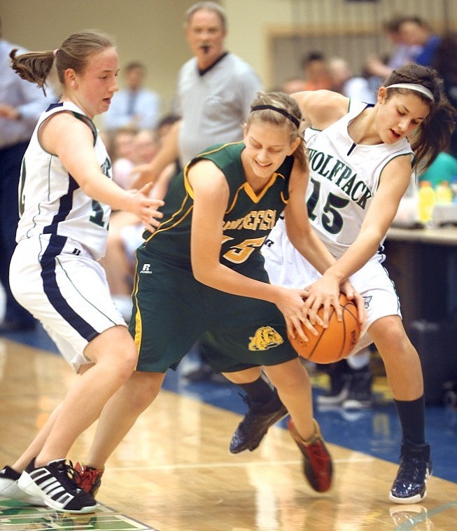 Whitefish junior Karissa Demarco, number 15, is pressured by Glacier junior Cami Mathison, number 12, and freshman Nicole Heavirland, number 15, during their game on Tuesday night. Glacier won the match up 61 to 29.