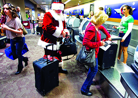 &lt;p&gt;In this Wednesday, 21, 2011, file photo, holiday travelers, including Donald Occimio of Mesa, Ariz., dressed as Santa Claus, and his wife Diane check in with customer service agent Angelee Arciniega, right, for their Southwest Airlines flight at the Terminal 4 ticketing area at Sky Harbor International Airport, in Phoenix. The 2012 Christmas travel season could be the busiest in six years, with AAA predicting that 93.3 million Americans will hit the road.&lt;/p&gt;