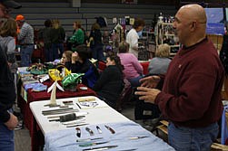 Knife maker Bob Crowder explains his wares to an attendee of the Thompson Falls Christmas Bazaar.
