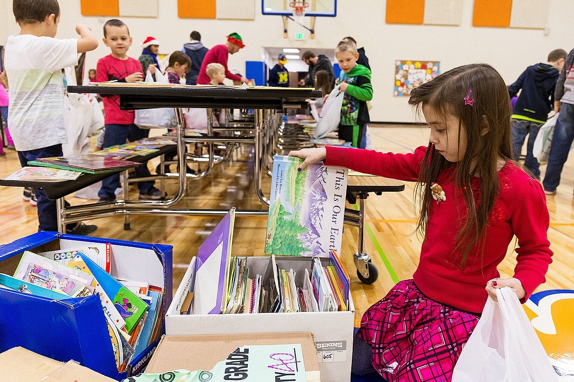 &lt;p&gt;Stella Stockdale, a kindergartner at Winton Elementary, inspects a box of books while making her final choices.&lt;/p&gt;