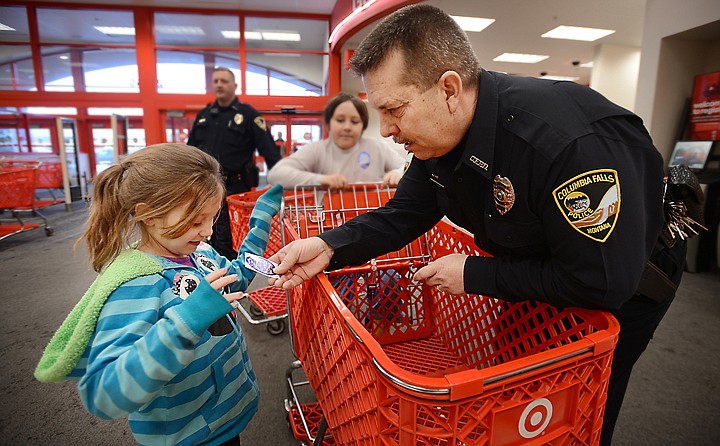 &lt;p&gt;Steve Hughes of the Columbia Falls Police Department gives a badge sticker to Tory Lewis, 6, before the police officers and children split up to go shopping on Wednesday at Target during the annual Shop with a Cop outing. (Brenda Ahearn photo/Daily Inter Lake)&lt;/p&gt;