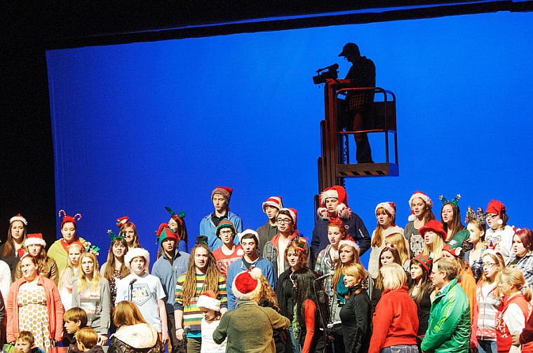 &lt;p&gt;David Pickeral, behind, films Whitefish High School choirs perform We Wish You a Merry Christmas Wednesday evening at the Whitefish Performance Arts center. The U.S. Troop Fund set up the performance to be filmed to send to troops overseas. Dec. 11, 2013 in Whitefish, Montana. (Patrick Cote/Daily Inter Lake)&lt;/p&gt;