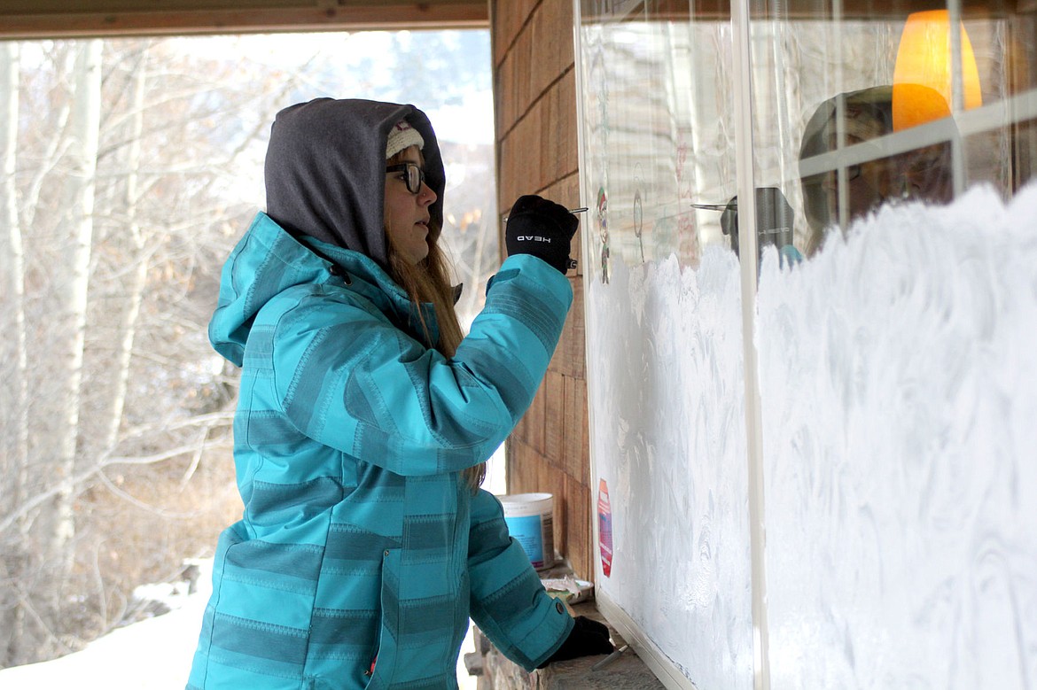 &lt;p&gt;&lt;strong&gt;Makenna Smith paints in the small details of the North Pole scene she and her partner, Jeffrey Marshall, put on the window of the Plains Subway.&lt;/strong&gt;&lt;/p&gt;
