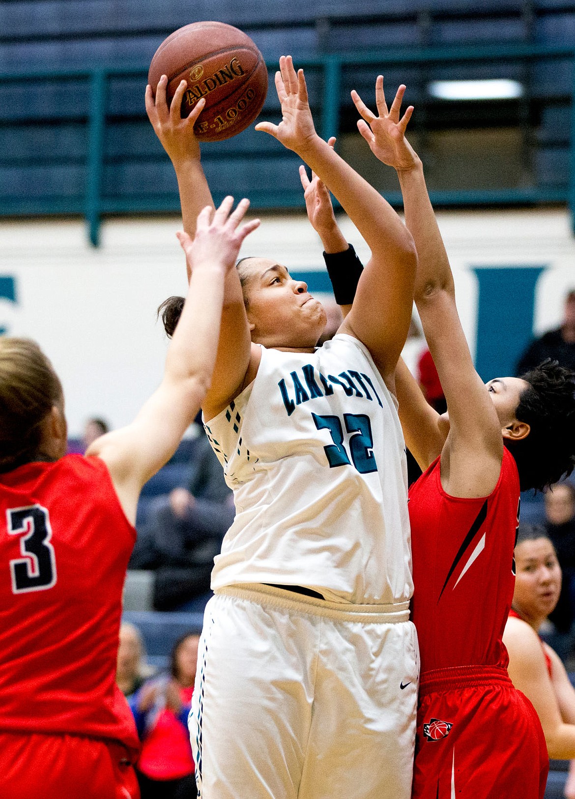 <p>JAKE PARRISH/Press Lake City junior Keara Simpson (32) battles through the arms of Audrey Dingel (3) and Reagan Hall of Boise on Friday at Lake City High School.</p>