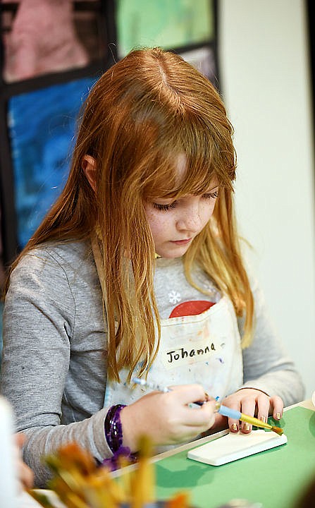 <p>Johanna Perkins, 8, of Whitefish, paints ceramic ornaments at the Stumptown Art Studio Santa's Workshop on Monday, Dec. 14, in Whitefish.</p>