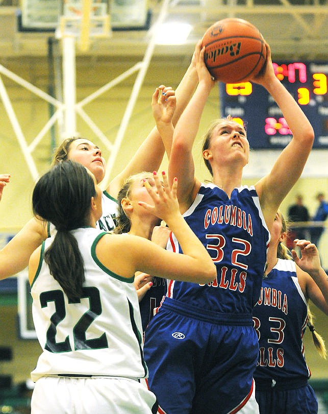 <p>Columbia Falls' Kiara Burlage puts up a shot after pulling down a rebound in a crowd of Wolfpack defenders. (Aaric Bryan/Daily Inter Lake)</p>