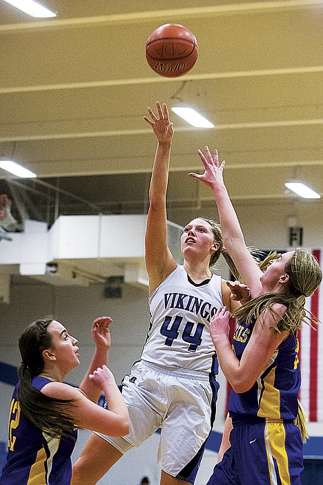 <p>Sydney Williams, a Coeur d'Alene forward, goes up for a second quarter jump shot Lewiston defenders Paige Wells, left, and Brett Hastings.</p>