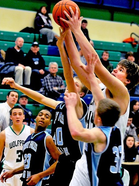 Glacier's Ryan Edwards fights through the Great Falls High Bison to gets his hands on a ball passed into him by teammate Trey Griffith (3) during Friday evening's Class AA home game.