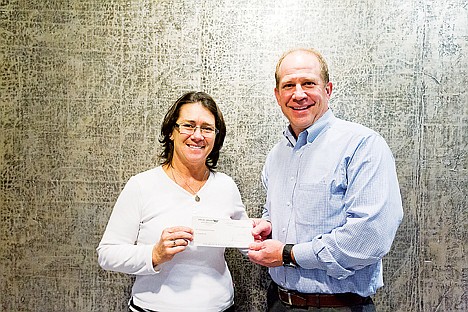 &lt;p&gt;Katie Burke, with the Coeur d'Alene Press advertising staff, accepts a donation from Phil Boyd, president and principal engineer for Welch-Comer Engineers Monday for the Press Christmas for All program.&lt;/p&gt;