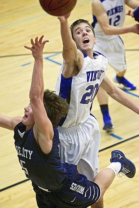 <p>Coeur d'Alene High's Justin Carpenter blocks a shot put up by Justin Pratt from Lake City High during the second half of the T-Wolves 44-40 win Tuesday over the Vikings.</p>