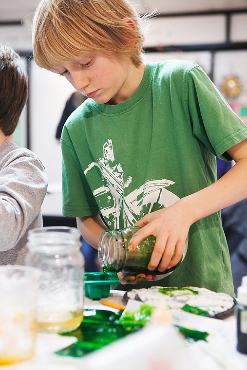 <p>Ruedi, 8, pours his mix of melted glycerine, coloring and fragrance into a mold Tuesday evening at Stumptown Art Studio in Whitefish. After about a day of sitting, the mixture will be scented soap.</p>