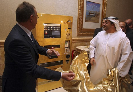 &lt;p&gt;Thomas Geissler, the CEO of Ex Oriente Lux, left, and an Emirati official remove the cover of an ATM-style kiosk which monitors the daily gold price and offers small bars up to 10 grams or coins with customized designs during an opening and demonstration ceremony at the Emirates Palace hotel in Abu Dhabi.&lt;/p&gt;