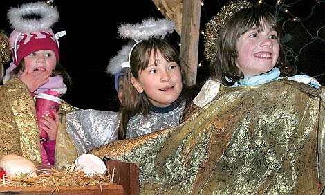 Photos by Sarah Leavenworth&lt;br&gt;Children from the Community Congregational Church flash angelic smiles to the crowd from the float - one of 49 entries in the Thompson Falls Christmas Parade. The girls (from left) are Megan Baxter, Grace Harnden and Jessie Wedel. The group from the church sang songs as the parade traveled down main street Wednesday.