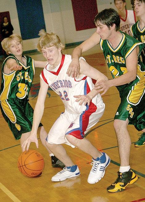 Photo by Aaric Bryan&lt;br&gt;Superior's Tyler Stenberg dribbles through St. Regis defenders Tim Cranley and Johnathon Kelley in Superior Friday.