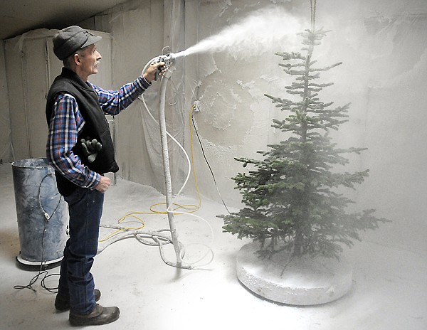 Foreman Clinton DeLong adds flocking to a tree on Friday, December 10, at the Snow Line Tree Company. DeLong has been with the company for 43 years.