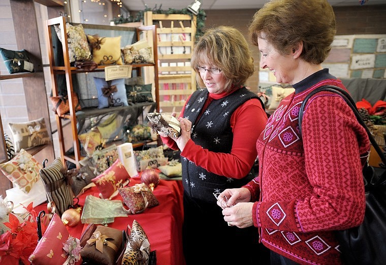 Darlene Cecil, left, maker of Pillow Talk (decorative lavender-filled pillows) helps Penny Frank of Kalispell with her shopping on Thursday at The Christmas Gift Shop.