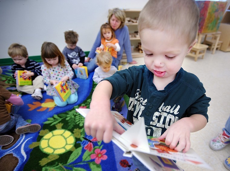 Cooper Logsdon, 2, of Kalispell curiously examines his new pop-up book on Wednesday at the Early Childhood Center at Flathead Valley Community College. Logsdon received the book through the My Own Book program.