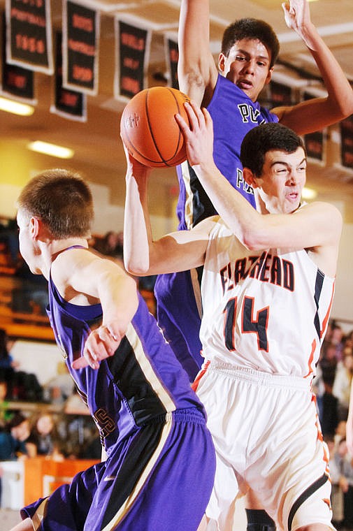 &lt;p&gt;Flathead senior Tommie Owens (14) looks to pass as he fights his way past two Polson defenders Thursday night during a nonconference basketball game at Flathead High School.&lt;/p&gt;