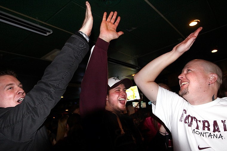 From left, Ty Cabral, Kevin Gauthier and Jeff Lozean high-five each other after a defensive stop by the Montana Grizzlies while watching Friday night&#146;s Football Championship Subdivision title game at Fatt Boys Bar and Grille in Kalispell. Fans&#146; first-half enthusiasm was shattered, however, as Villanova dominated the second half and dealt Montana another title-game defeat, 23-21. For more on the game, go to page B-1.