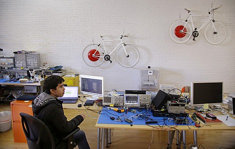 &lt;p&gt;James Simard, a hardware designer and embedded programmer, listens to a colleague as they talk while working on developments to the Copenhagen Wheel, a human/electric hybrid bicycle engine at Superpedestrian in Cambridge, Mass. on Dec. 12.&lt;/p&gt;